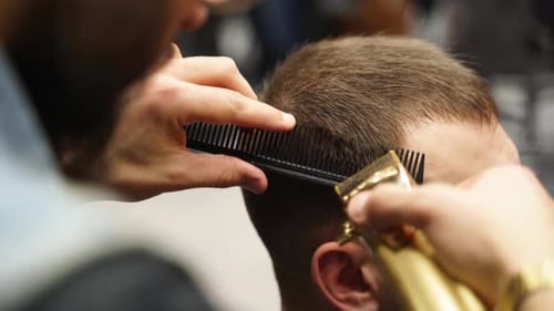 Barber Cuts Hair With Comb and Clippers