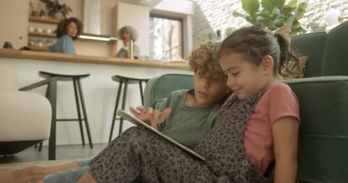 Two Children Using Tablet Together on Floor
