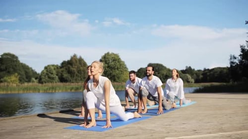 Fitness, Sport, and Healthy Lifestyle Concept - Group of People Making Yoga