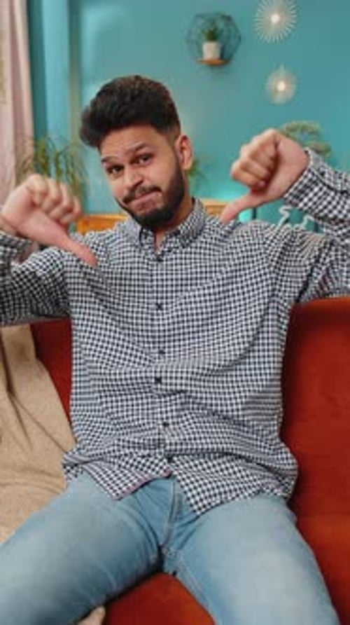 Upset Arabian Man Showing Thumbs Down Dislike Bad Work Disapproval Dissatisfied Feedback at Home