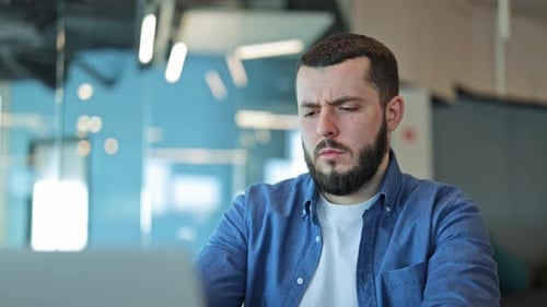 Bearded Worker Suffers Headache At Office Desk