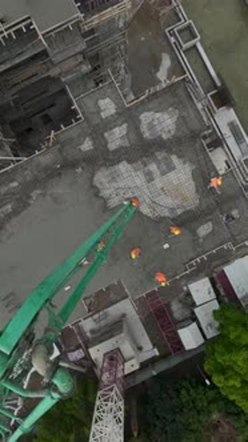 Vertical Video Workers Pouring Concrete for a Modern Residential Highrise Foundation on a Dynamic