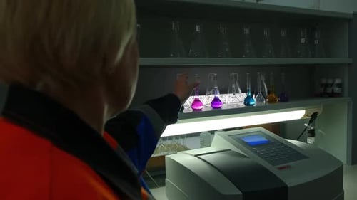 Woman Scientist Examining Colorful Chemical Solutions