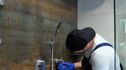 Manitas profesional trabajando en cabina de ducha en interiores