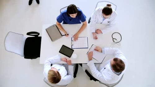 Medical professionals meeting at table, birds eye view