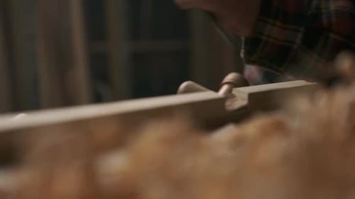 Carpenter working with pouch in moody workshop