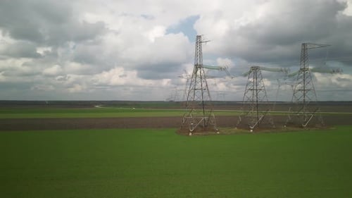 Aerial View of Power Lines Over Green Agricultural Field