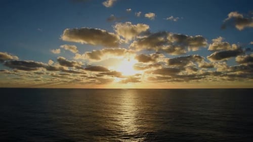 Breathtaking Ocean Sunset View with Scattered Clouds and Horizon