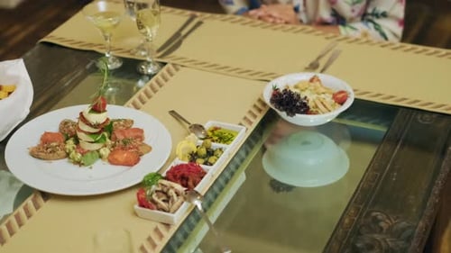 Waiter serving a plate of pasta to a woman guest in a fine restaurant. Slow motion close up. 4K
