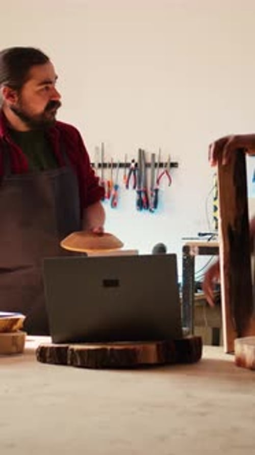 Vertical Video Woodworker Looking Over Blueprints on Laptop Brainstorming with Colleague