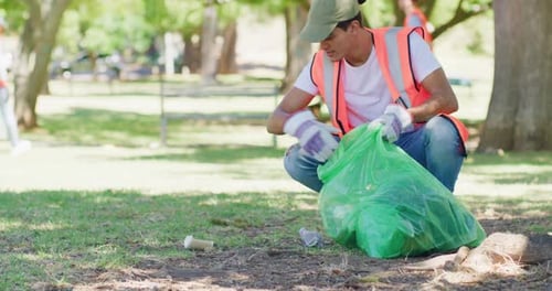 Male volunteer cleaning a park in his community