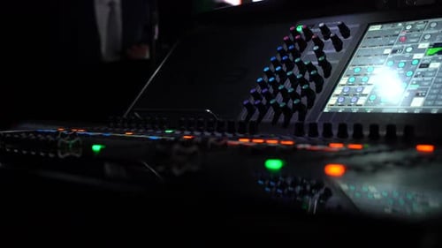 Sound Engineer Adjusting Audio Levels on Mixing Console