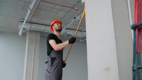 Professional Painter Painting a Wall in New Office