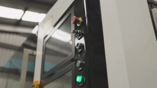 Caucasian worker hand pressing green button to start Industry CNC machine