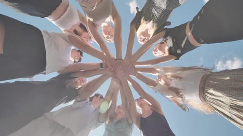 Group of Young People is Joining Hands Forming a Circle in the Sky While Smiling