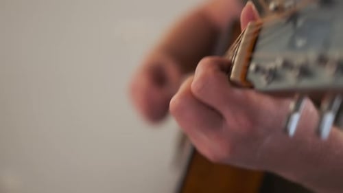 Closeup of Young Man Playing Acoustic Guitar