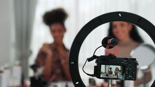 Dos mujeres influencers graban una transmisión en vivo de un vlog, una reseña de un vídeo, maquillaje, crucial