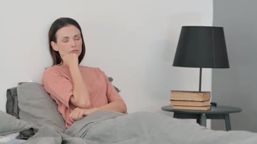 Woman resting in bed with eyes closed