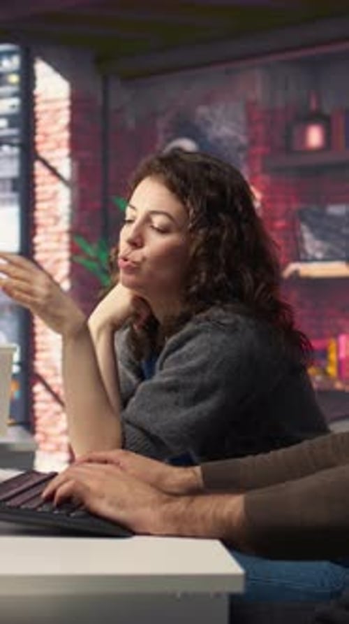 Woman Collaborating with Colleague at Computer in Office