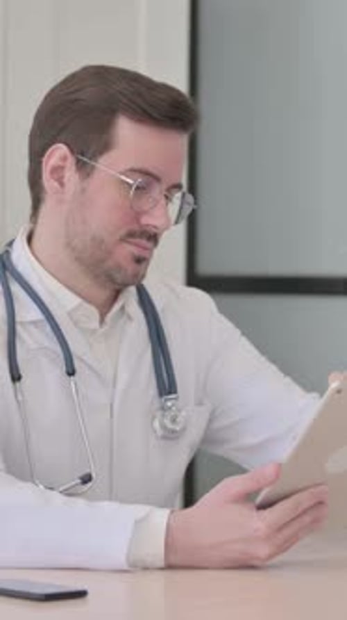 Doctor Browsing Tablet in Clinic, vertical video