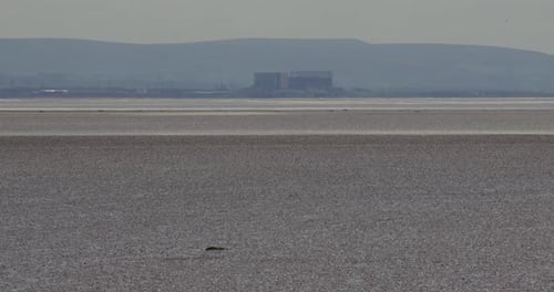 Long shot of Heysham Nuclear Power Station in Morecambe Bay at low tide on the A5057, Goads Barrow,
