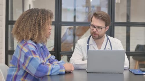 Doctor Talking with African Woman in Clinic