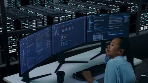Side View Of Bored Asian Woman Developer Write Code In Data Center
