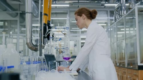 Scientist Works on Laptop in Bright Laboratory