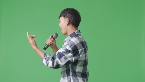 Side View Of Young Asian Teen Boy Holding A Microphone And Rapping On ...