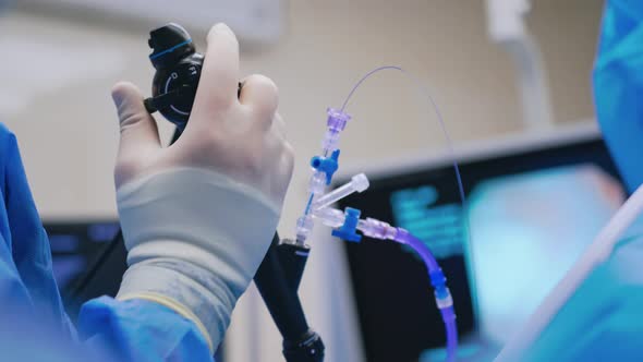 Endoscopic surgery. Surgeon's hand holds medical instrument on the blur ...