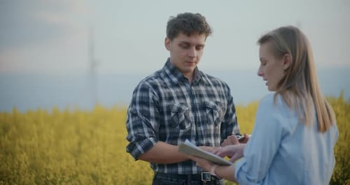 Farmer And Agronomist Discussing In Farm During Sunset