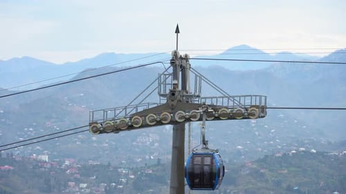 Blue funicular cable car offers a scenic touristic ride to reach destination, against the overcast