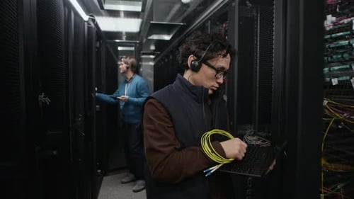Two Network Engineers Inspecting Server Racks in Data Center