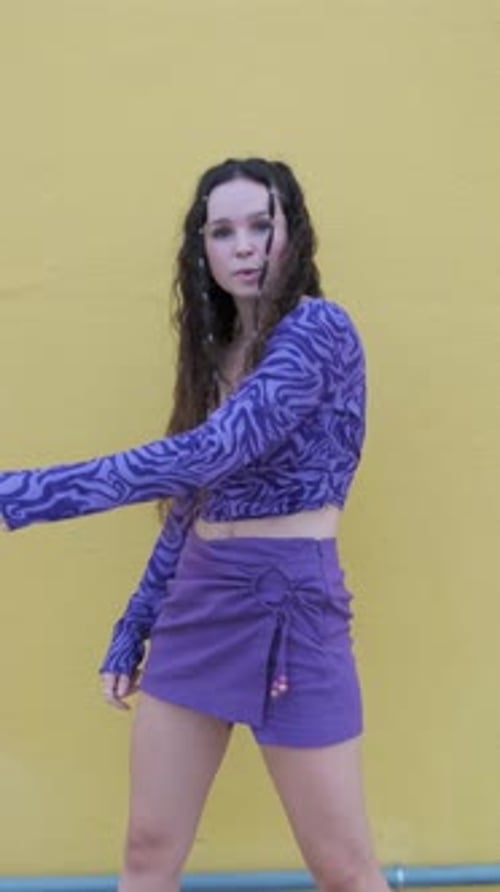 Woman Dances in Front of Yellow Wall