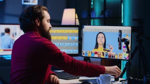 Male Photographer Editing Pictures at Computer in Dark Office