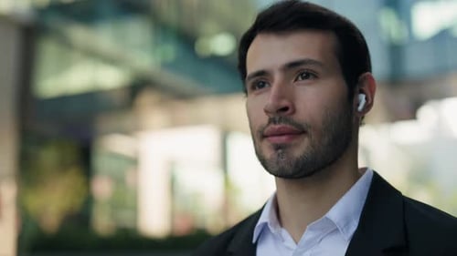 Professional Man with Wireless Earbuds in Urban Setting