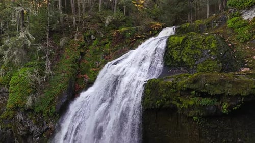 Waterfall in forest in the pacific northwest 4K drone footage sideview descending.to base of waterfa