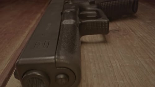 Atemberaubender Makro-Dolly-In der Glock 17-Handfeuerwaffe auf einer Holzoberfläche