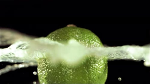 Half Lime Falling and Splashing on White Background