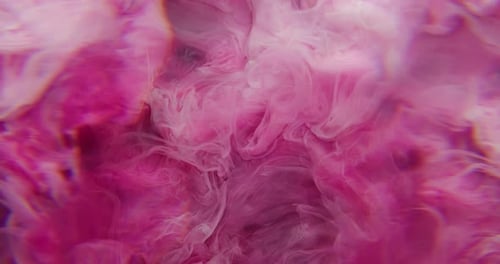 Swirling vibrant pink ink dissolving in water abstract