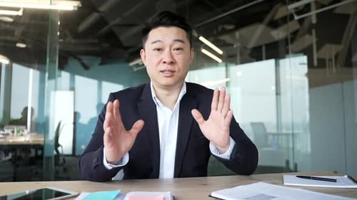 Webcam view. Confident asian businessman talking on a video call conference looking at camera