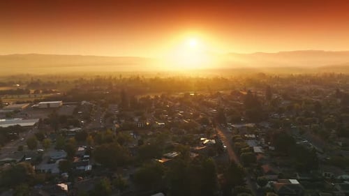 Amazing orange bright sky over Napa, California, USA. Drone flying over the cozy houses in the rays