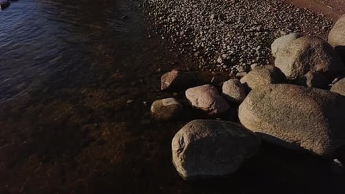 Rocky beach shore with many boulders and blue sea nordic nature