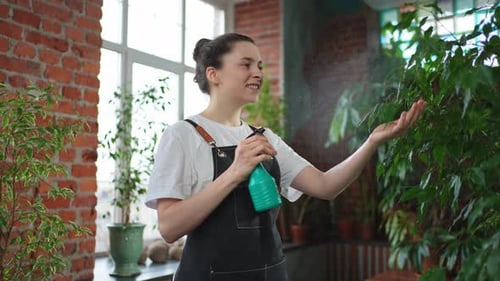 Running of Own Business Young Woman Florist with Spray Bottle Watering Fertilizing Plants in
