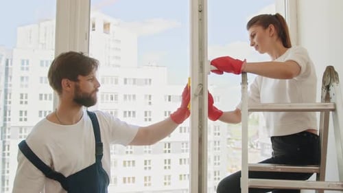 Junges glückliches Paar hat Spaß beim Putzen zu Hause