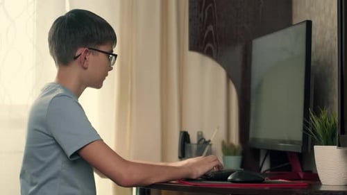 Young Person Typing at Computer Indoors