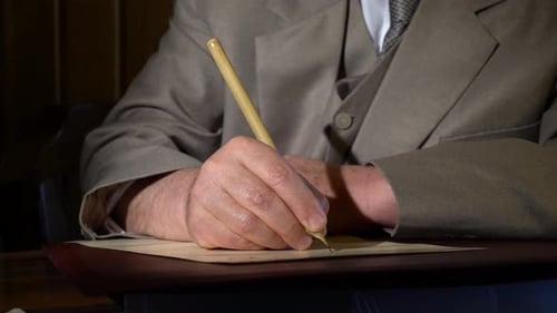 Man Writes with Quill on Parchment Close Up
