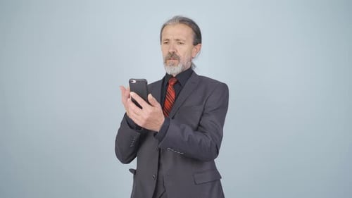 Gray Haired Man Video Conferencing on Smartphone