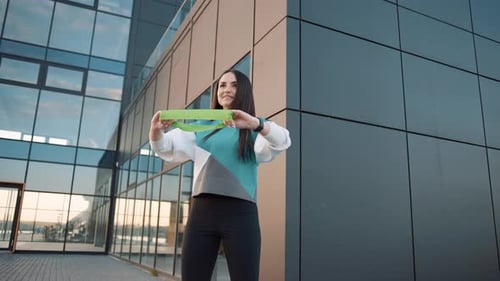 Woman Stretching Resistance Band in Urban Setting