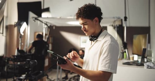 Typing, producer and man with tablet for editing software, photoshoot and production in studio